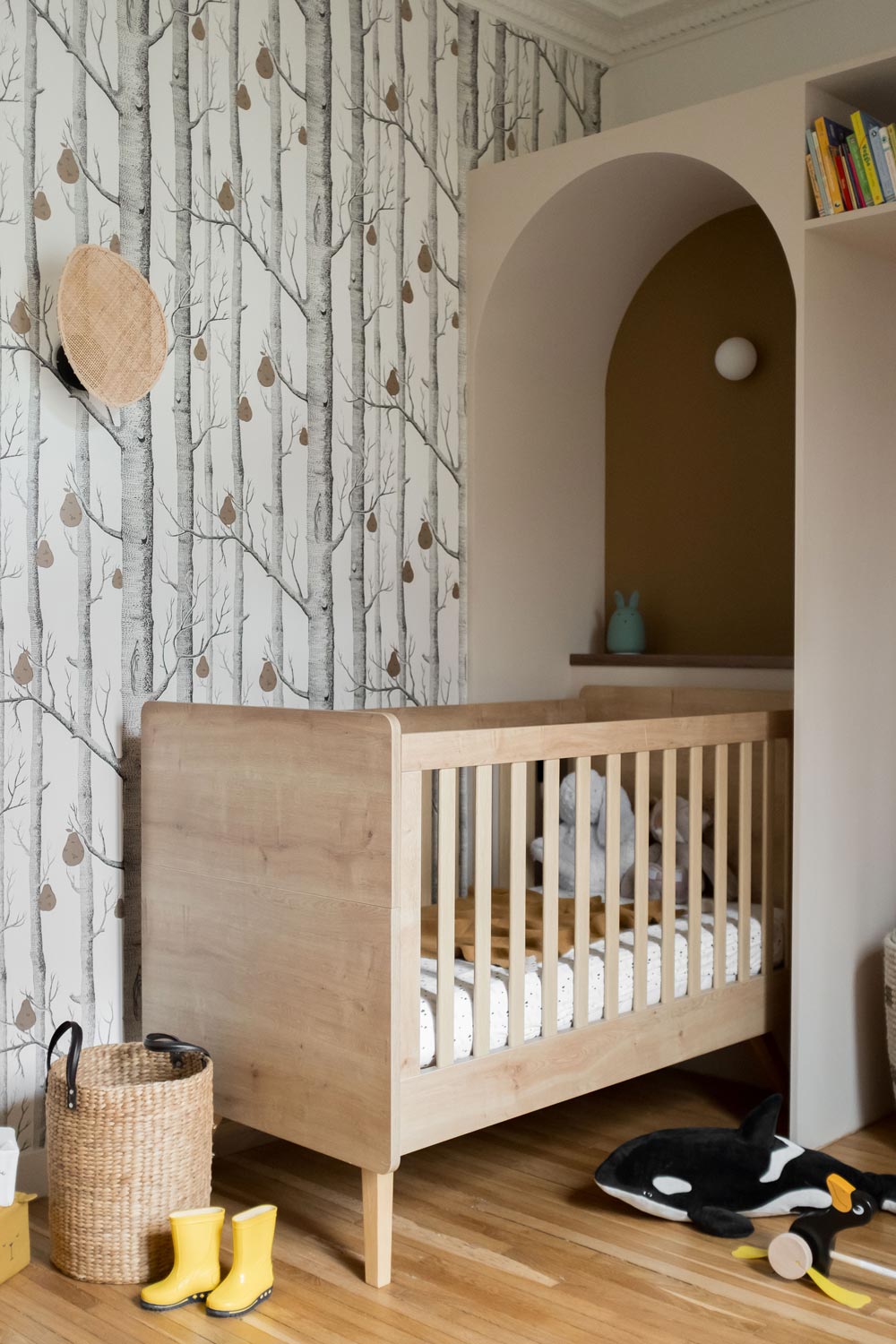 Chambre d'un bébé, lit en bois encastré dans une niche menuisée