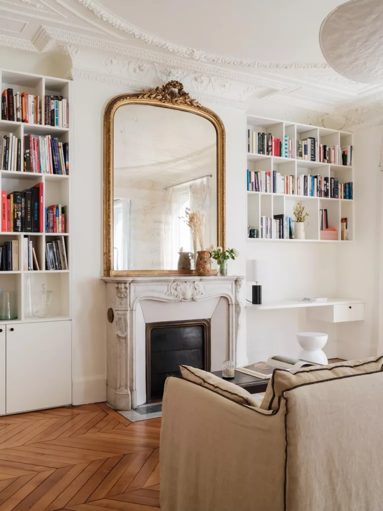 Bibliothèque autour d'une cheminée en marbre blanc dans un appartement parisien