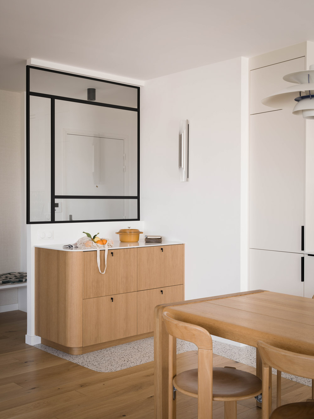Verrière noire, meuble en chêne sur mesure et salle à manger dans l’appartement Simone Veil.