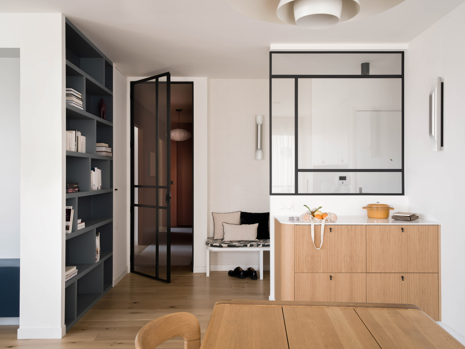 Vue générale de l’appartement Simone Veil avec verrière, bibliothèque et meuble en chêne sur mesure.